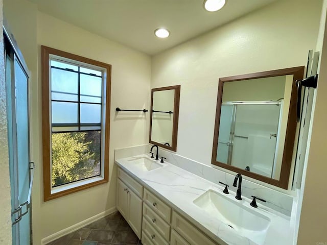 bathroom featuring a shower with door and vanity