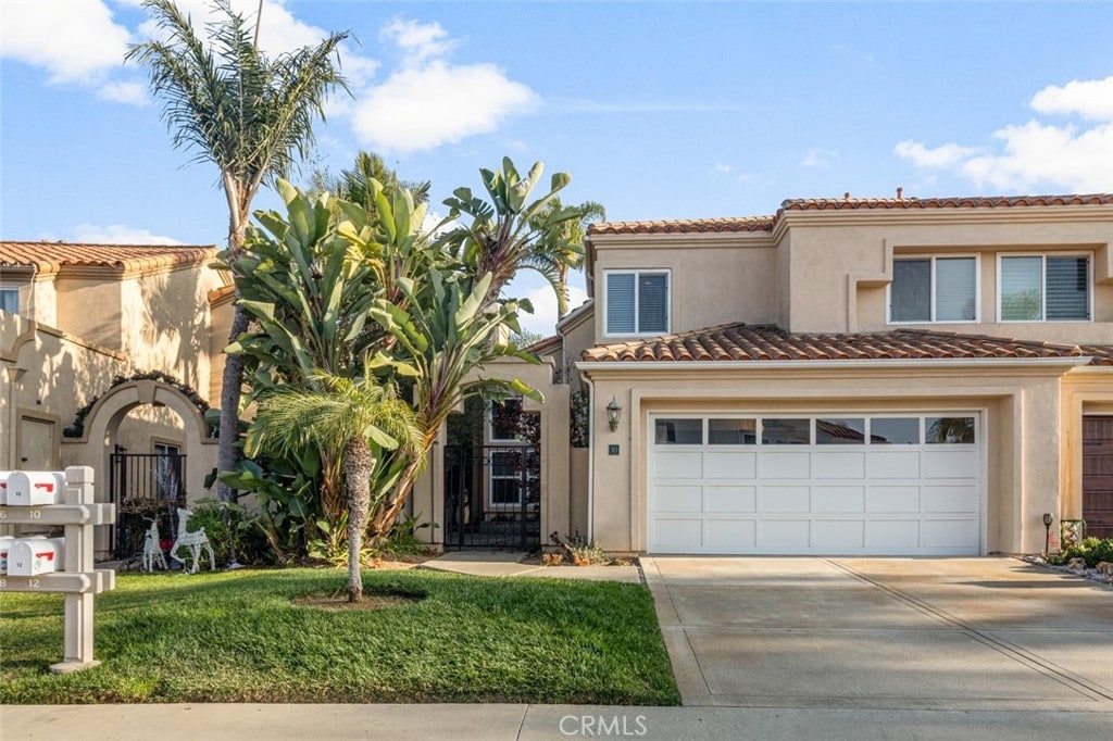 mediterranean / spanish-style house featuring a garage and a front yard