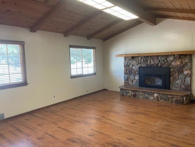 unfurnished living room featuring wood ceiling, a fireplace, lofted ceiling with beams, and hardwood / wood-style flooring