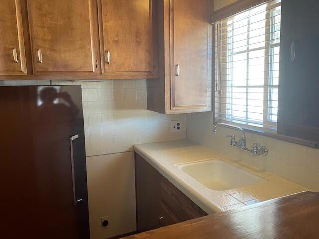 kitchen with backsplash, sink, and refrigerator