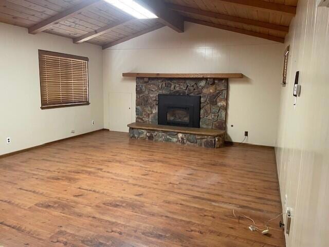 unfurnished living room with a stone fireplace, wooden ceiling, lofted ceiling with beams, and hardwood / wood-style flooring