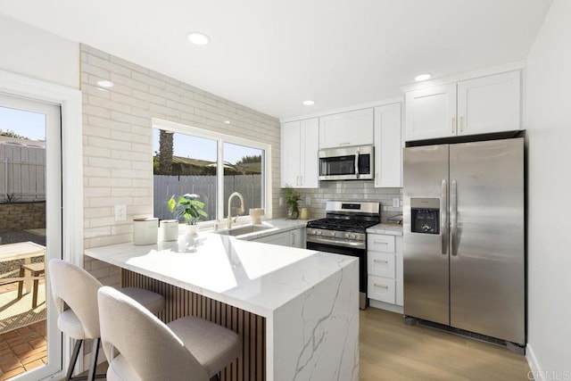 kitchen featuring appliances with stainless steel finishes, sink, white cabinetry, and plenty of natural light