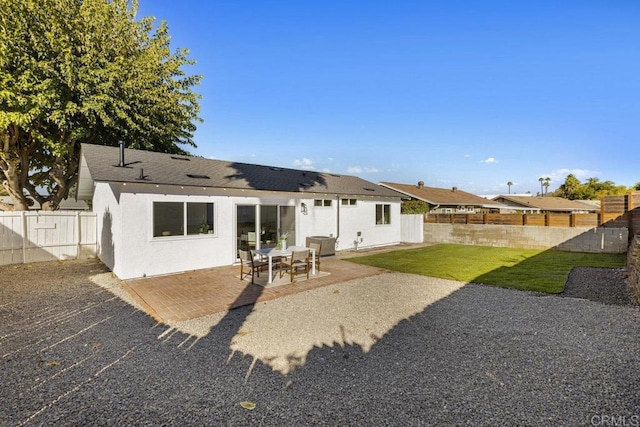 back of property with a yard and a patio