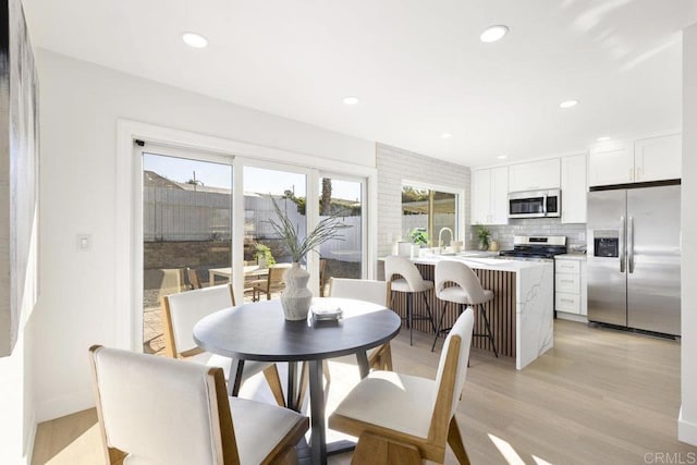 dining room featuring light wood-type flooring and sink