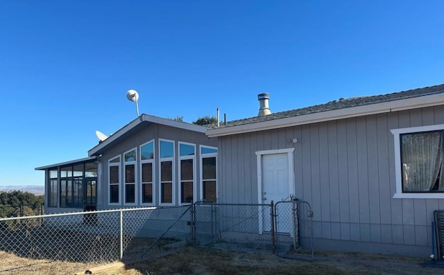 view of property exterior with a sunroom