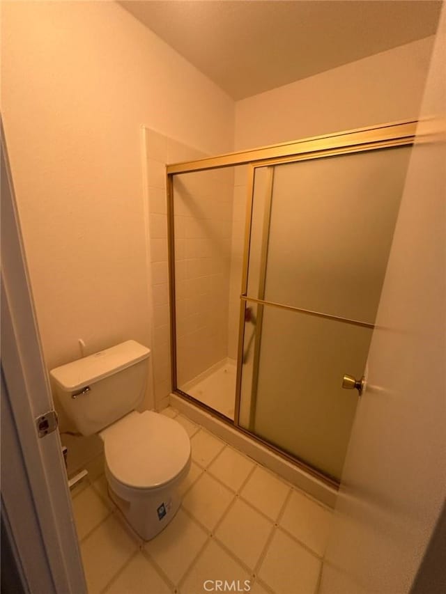 bathroom with a shower with door and toilet