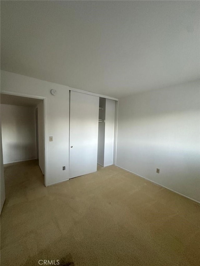 unfurnished bedroom featuring a closet and carpet flooring