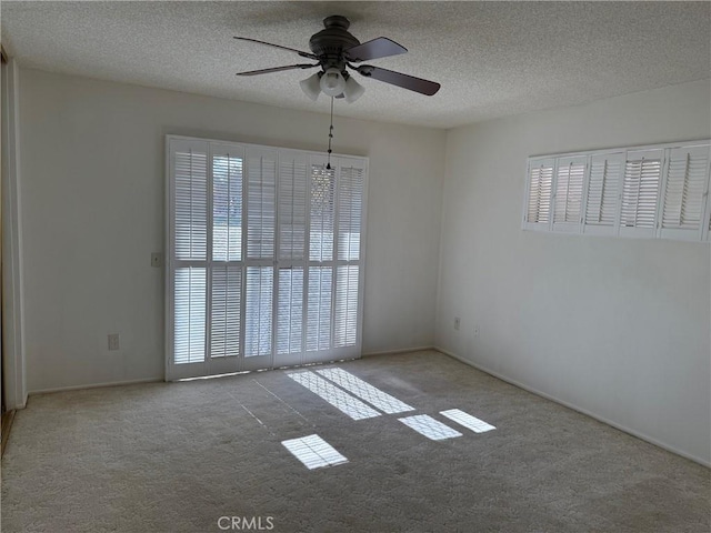 carpeted empty room with a textured ceiling and ceiling fan