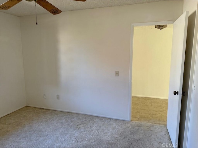 carpeted spare room featuring a textured ceiling and ceiling fan