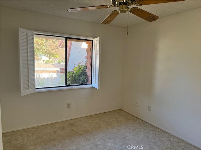 carpeted spare room with ceiling fan and a textured ceiling