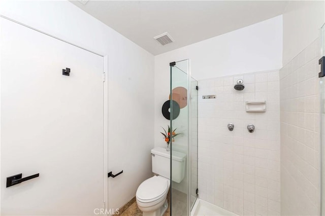 bathroom with toilet and a tile shower