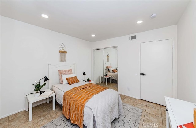 bedroom with light tile patterned floors and a closet