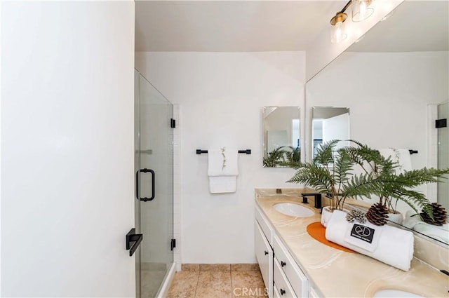 bathroom featuring a shower with shower door and vanity