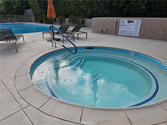 view of pool featuring a community hot tub and a patio