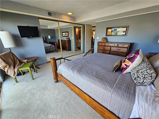 bedroom featuring carpet, a textured ceiling, and a closet