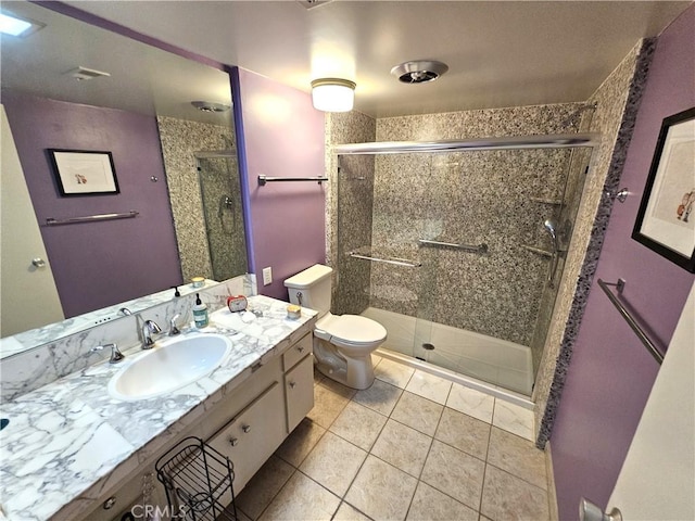 bathroom with tile patterned flooring, vanity, toilet, and a shower with door