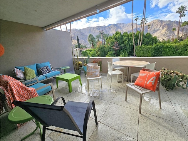 view of patio / terrace with a mountain view, a balcony, and an outdoor hangout area