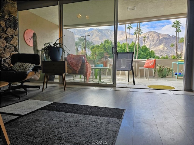 doorway with hardwood / wood-style flooring, plenty of natural light, and a mountain view