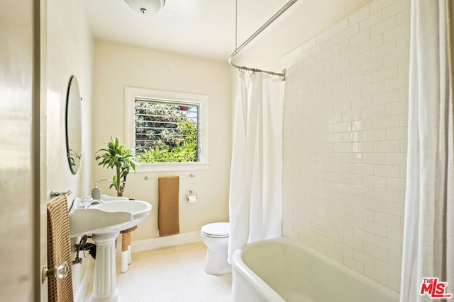 bathroom featuring tile patterned flooring, shower / bath combination with curtain, and toilet