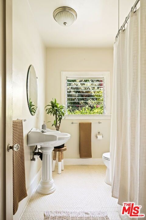 bathroom featuring toilet, walk in shower, and radiator