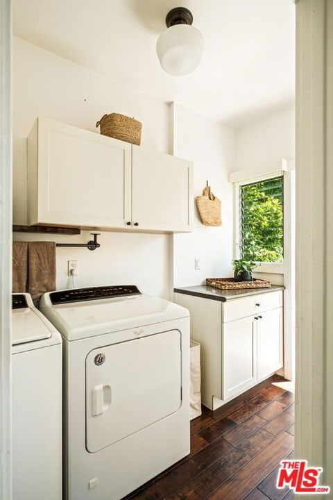 laundry room featuring washer and dryer, dark wood-type flooring, and cabinets