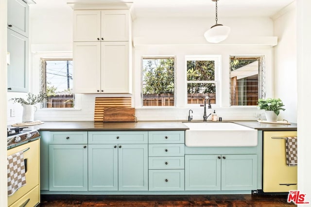 kitchen featuring range, hanging light fixtures, a healthy amount of sunlight, and sink