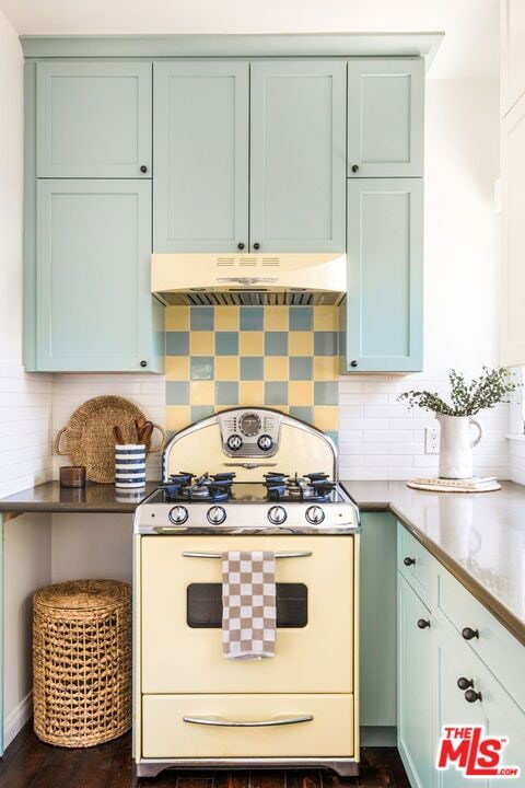 kitchen with dark hardwood / wood-style floors, white range with gas stovetop, green cabinetry, and tasteful backsplash