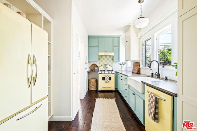 kitchen with tasteful backsplash, white appliances, dark wood-type flooring, sink, and hanging light fixtures