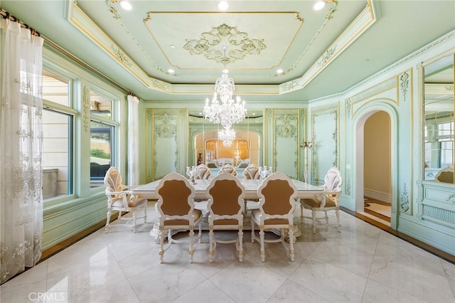 dining space featuring a chandelier, a raised ceiling, and crown molding