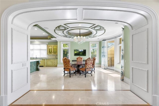 dining area featuring a notable chandelier, crown molding, and sink