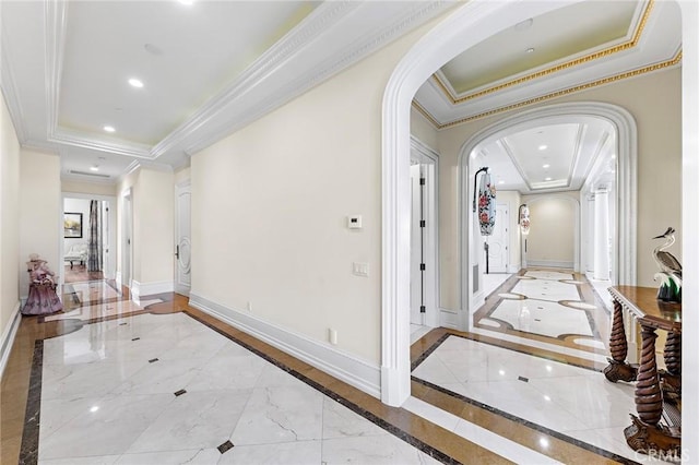 corridor with a raised ceiling and crown molding