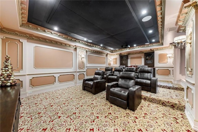 carpeted cinema with a raised ceiling and crown molding