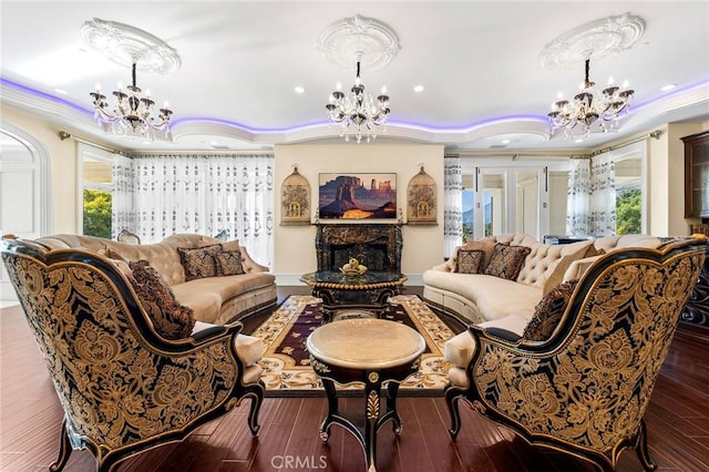 living room featuring a fireplace, dark hardwood / wood-style floors, an inviting chandelier, and ornamental molding