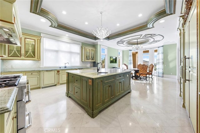 kitchen with hanging light fixtures, stainless steel gas range, a notable chandelier, a kitchen island with sink, and green cabinetry