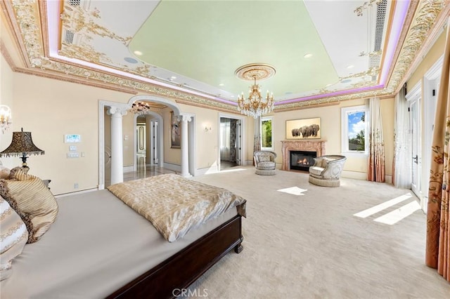 bedroom with ornamental molding, a tray ceiling, and light colored carpet