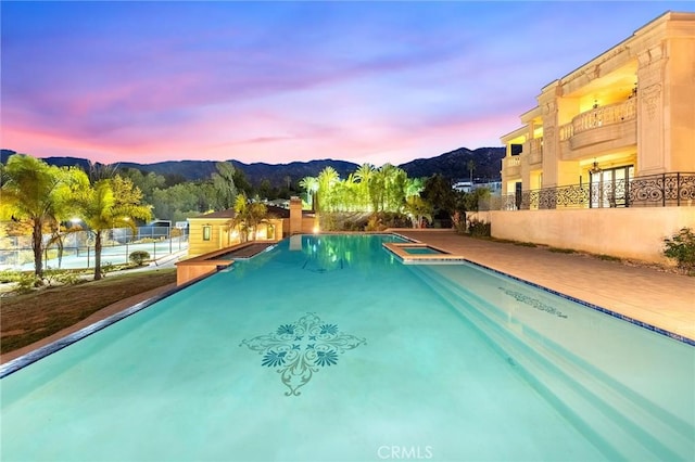 pool at dusk featuring a mountain view