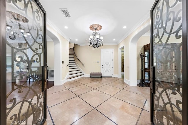 entrance foyer with a chandelier, crown molding, and light tile patterned flooring