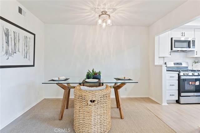 dining area with visible vents, baseboards, and light wood-type flooring