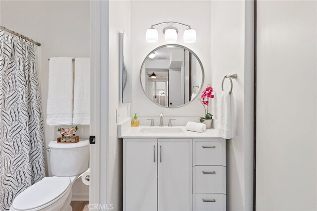 full bath with vanity, a ceiling fan, and toilet