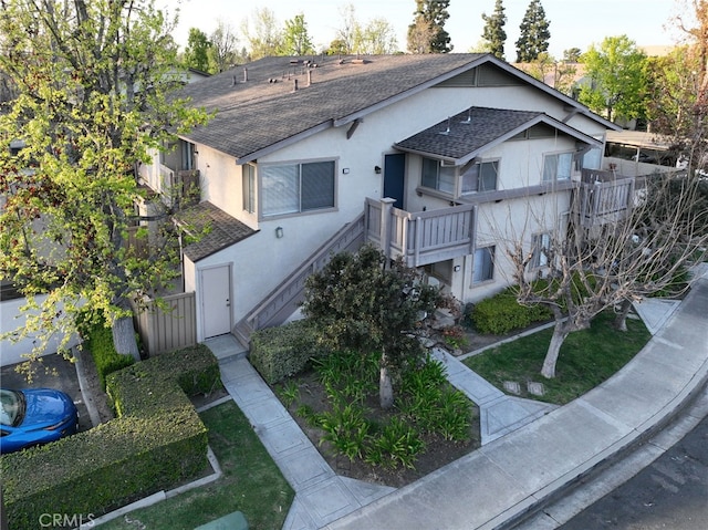 81 Smokestone Unit 12, Irvine, CA 92614 - view of front of house featuring a shingled roof, stucco siding, and stairway