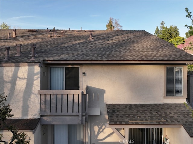 81 Smokestone Unit 12, Irvine, CA 92614 - back of property with a shingled roof, stucco siding, and a balcony