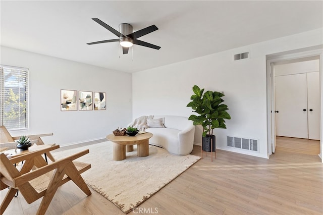 living area with a ceiling fan, baseboards, visible vents, and light wood-style flooring