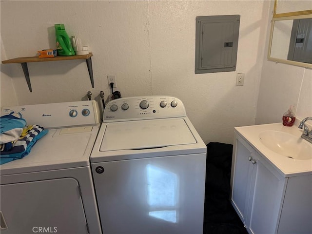 laundry area with electric panel, sink, and washer and dryer