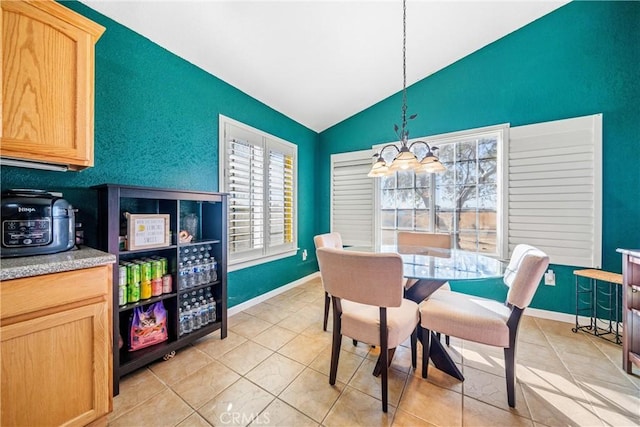 tiled dining area featuring an inviting chandelier and vaulted ceiling