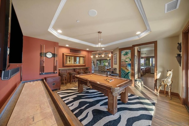 playroom featuring ornamental molding, a tray ceiling, light hardwood / wood-style flooring, bar, and pool table