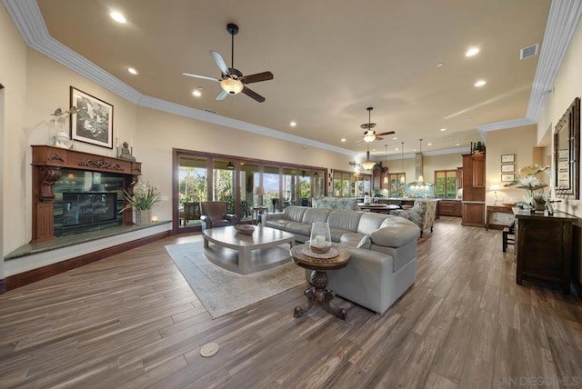 living room with ceiling fan, ornamental molding, and dark wood-type flooring