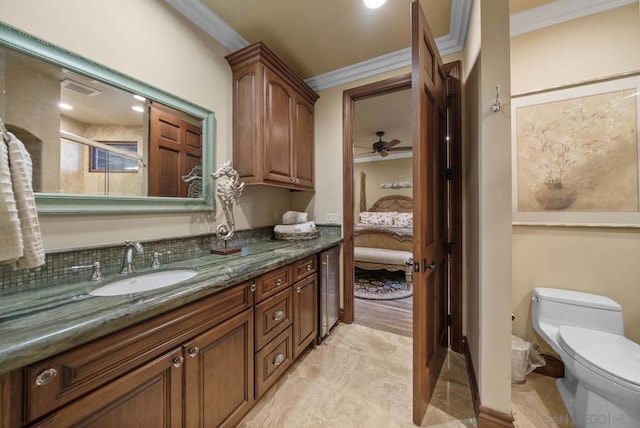 bathroom with vanity, crown molding, ceiling fan, and toilet