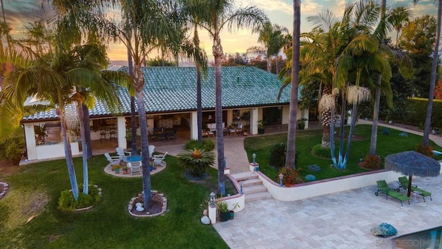 view of front of home with a lawn and a patio