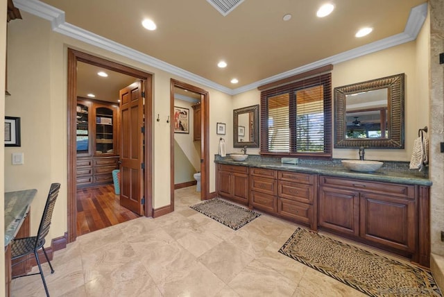 bathroom with crown molding, vanity, and toilet