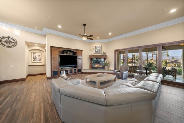 living room with hardwood / wood-style flooring, ceiling fan, and ornamental molding